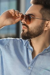 Handsome man in sunglasses outdoors on sunny day, closeup