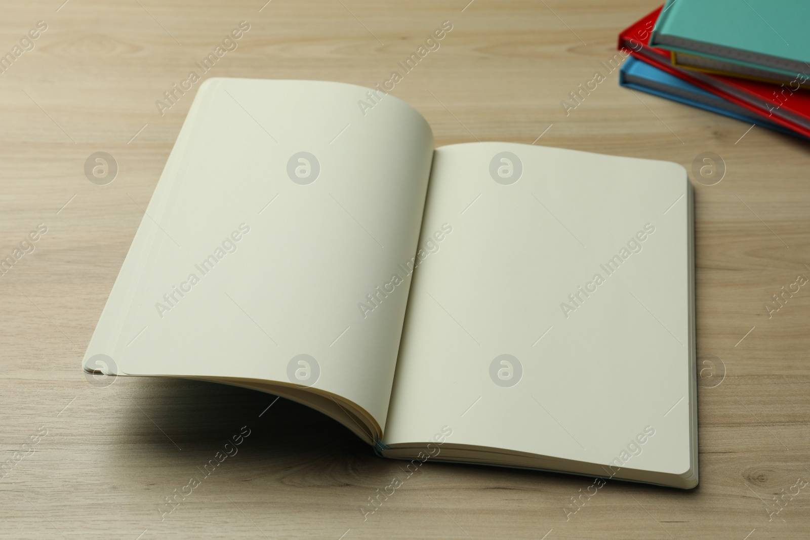 Photo of Open notebook on wooden table. Personal planning