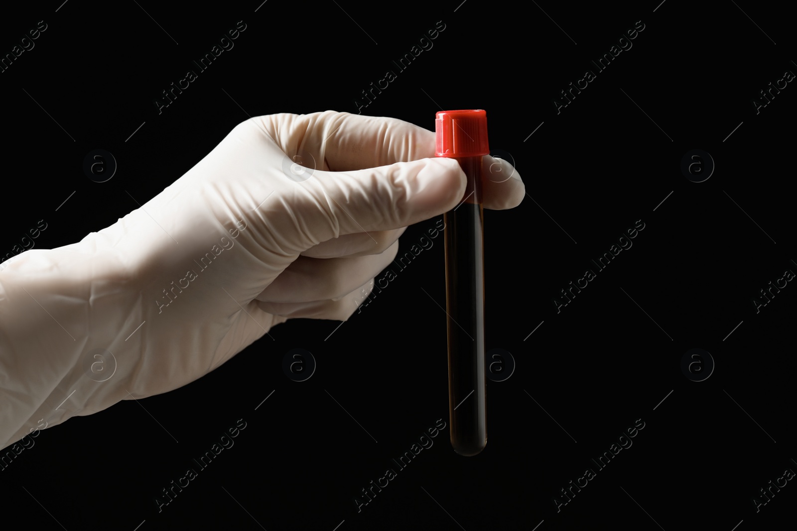 Photo of Scientist holding test tube with liquid on black background, closeup