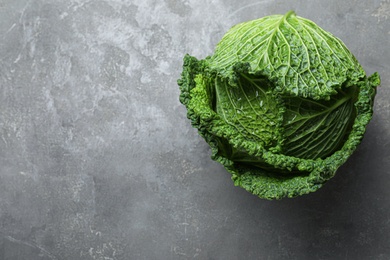 Fresh ripe savoy cabbage on grey table, top view. Space for text