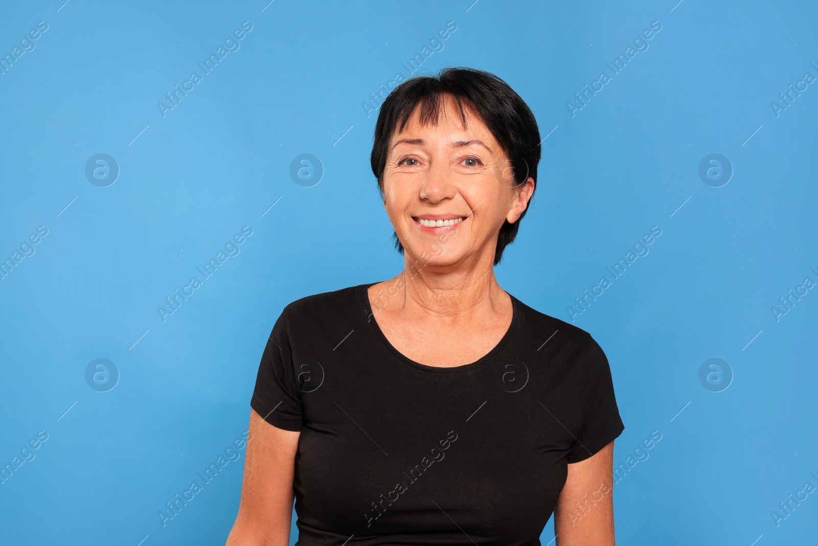 Photo of Portrait of smiling senior woman on light blue background