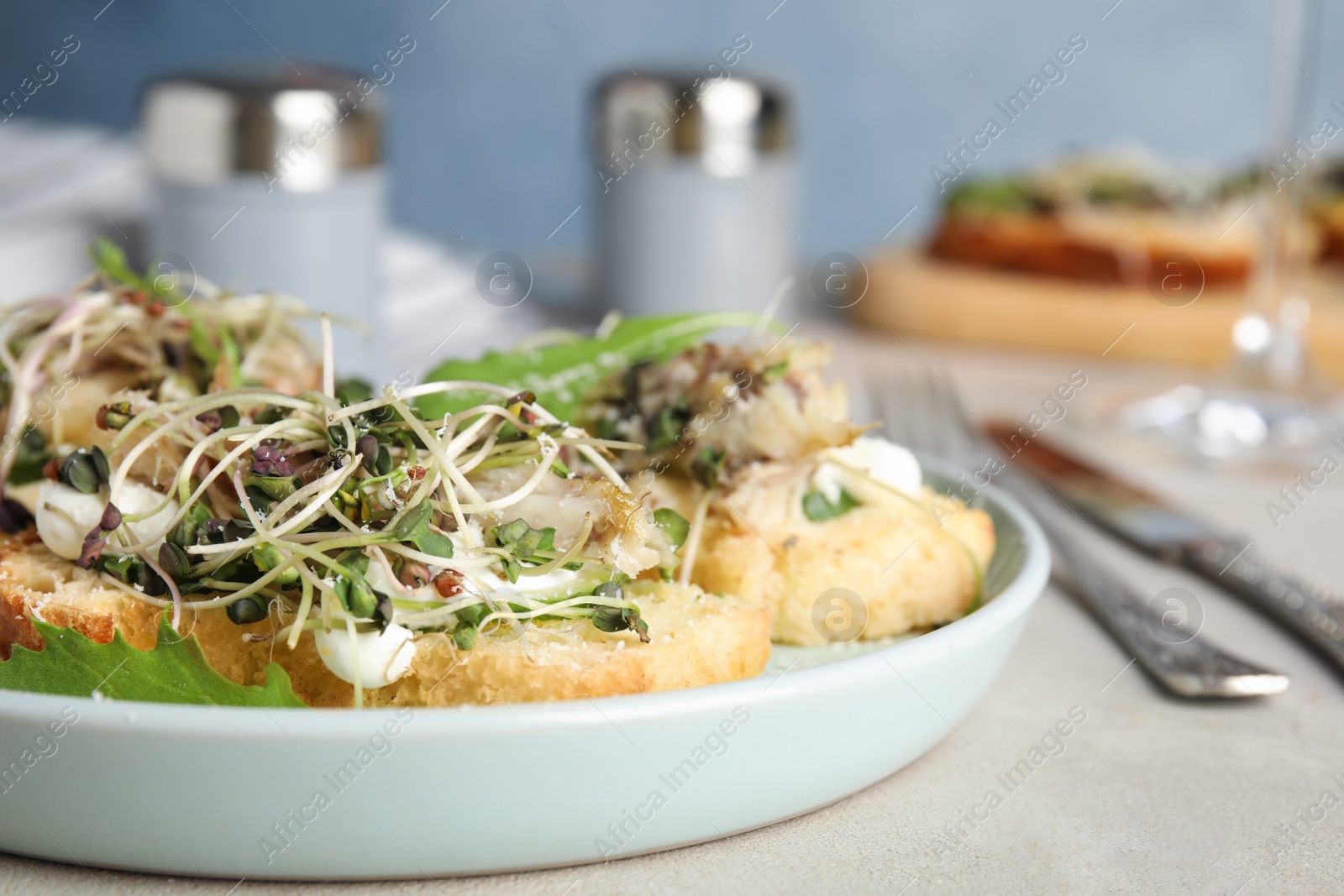 Photo of Delicious bruschettas with fish on light table, closeup