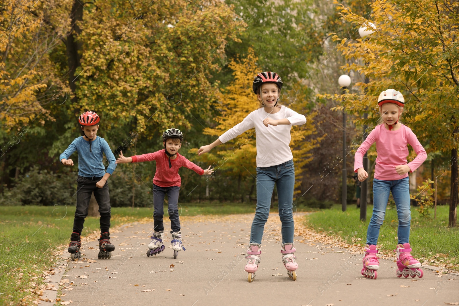 Photo of Happy children roller skating in autumn park