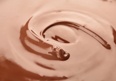 Photo of Delicious melted milk chocolate, closeup