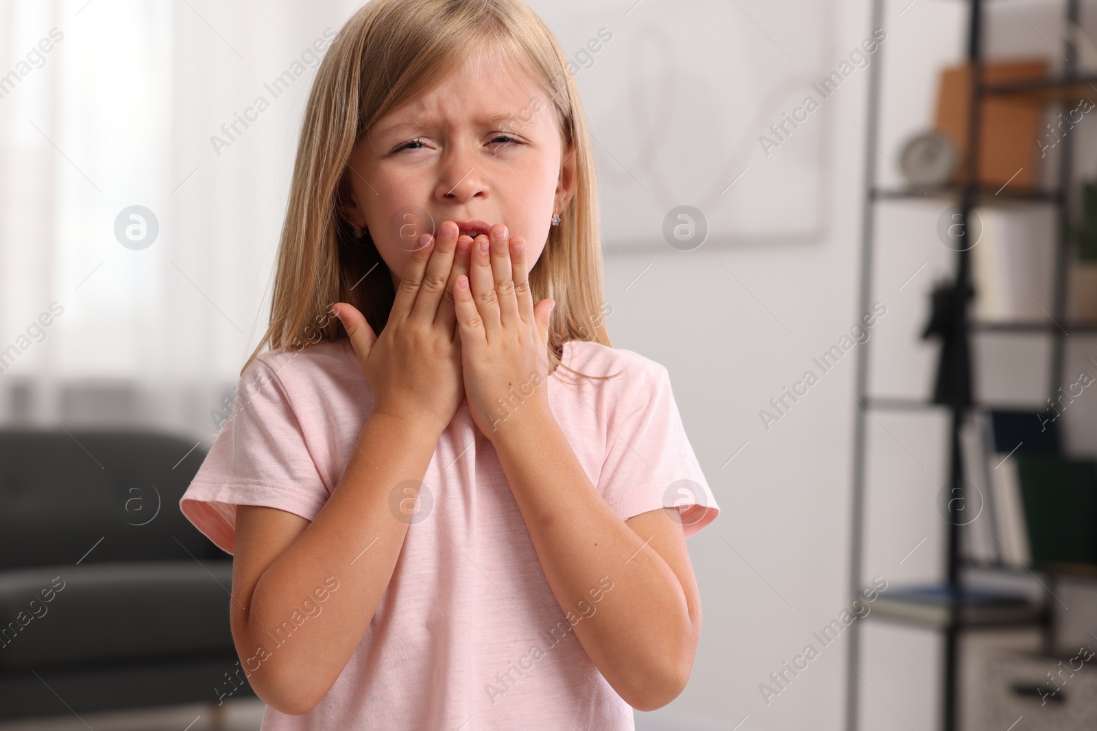 Photo of Suffering from allergy. Little girl sneezing at home