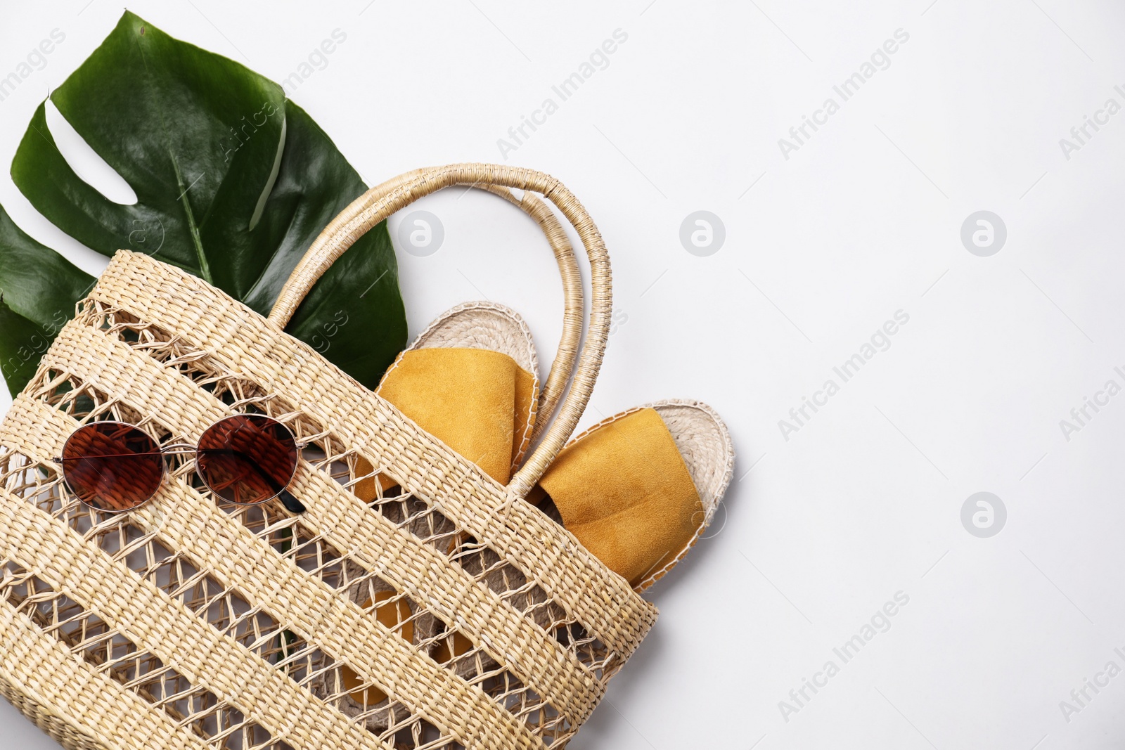 Photo of Stylish straw bag and summer accessories on white background, flat lay
