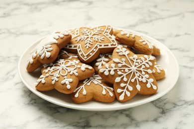 Tasty star shaped Christmas cookies with icing on white marble table, closeup