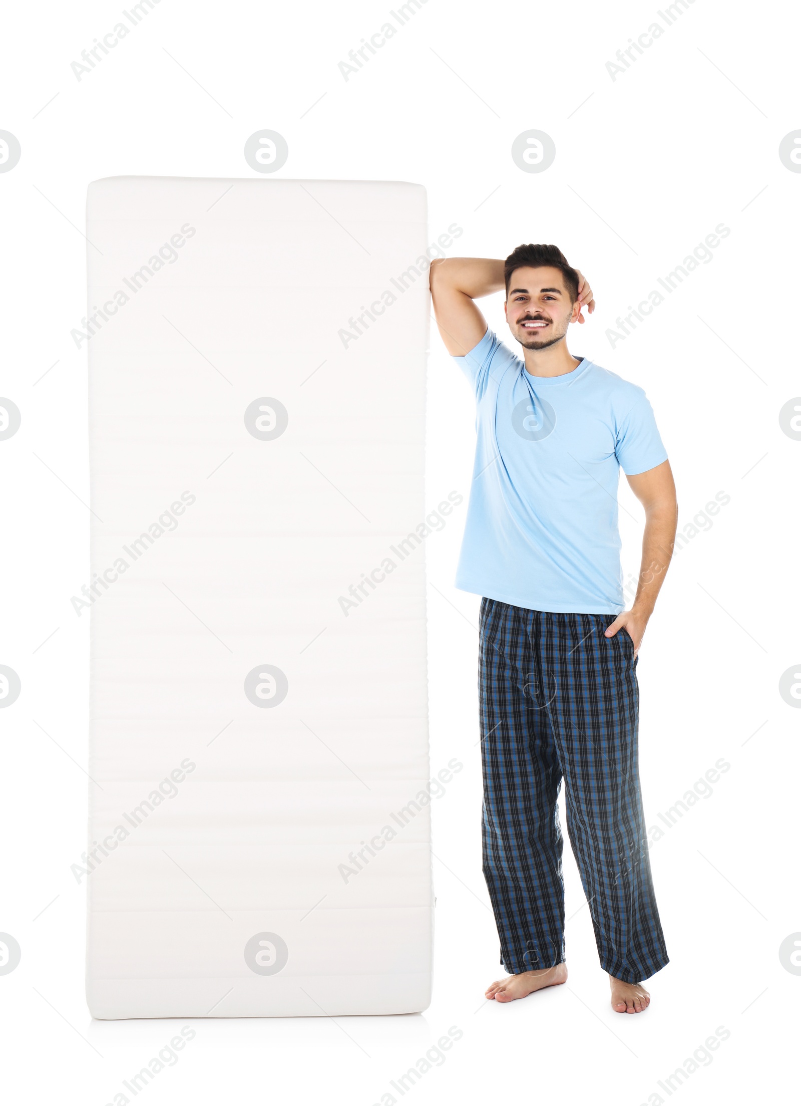 Photo of Young man with comfortable mattress isolated on white