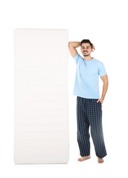 Young man with comfortable mattress isolated on white