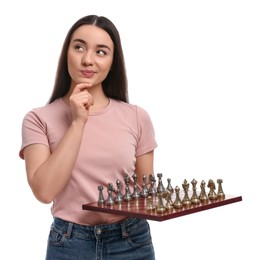 Thoughtful woman holding chessboard with game pieces on white background