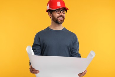 Photo of Architect in hard hat with draft on orange background