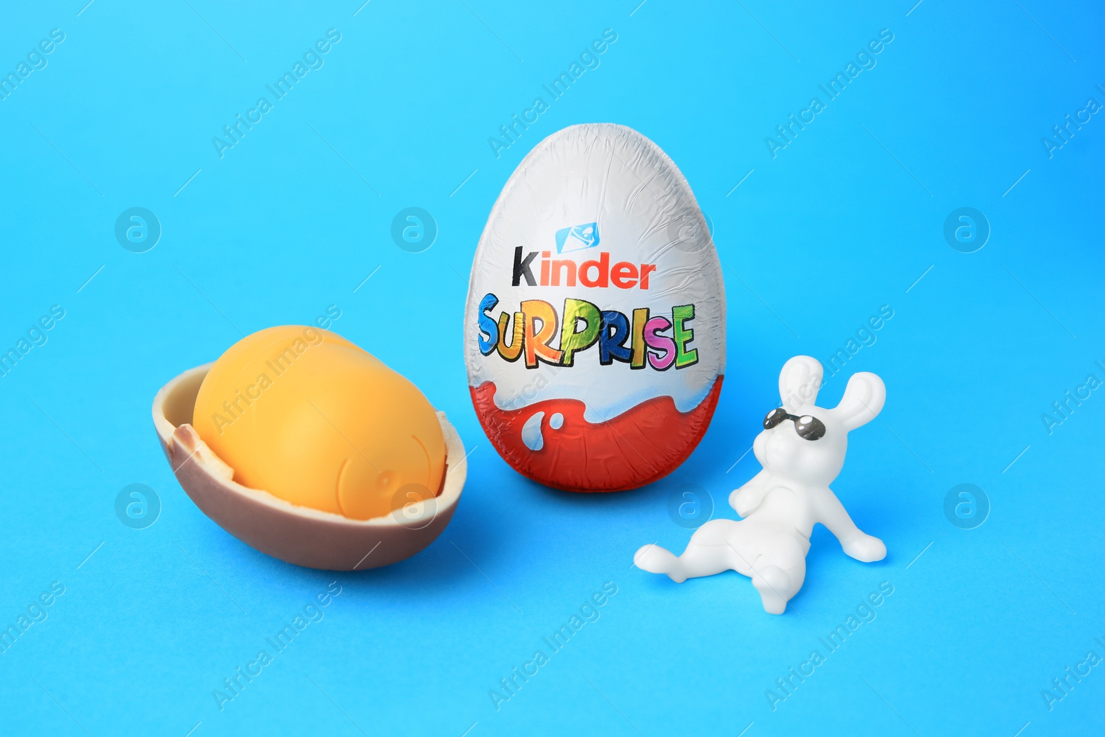 Photo of Slynchev Bryag, Bulgaria - May 25, 2023: Kinder Surprise Eggs, plastic capsule and toy bunny on light blue background