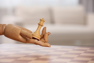 Wooden hand representing artificial intelligence. Robot with queen over chessboard against light background, closeup. Space for text