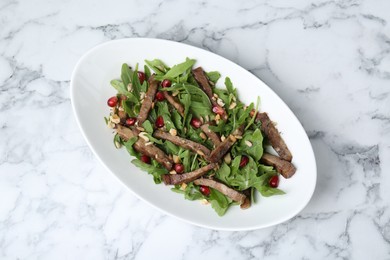 Delicious salad with beef tongue, arugula and seeds on white marble table, top view