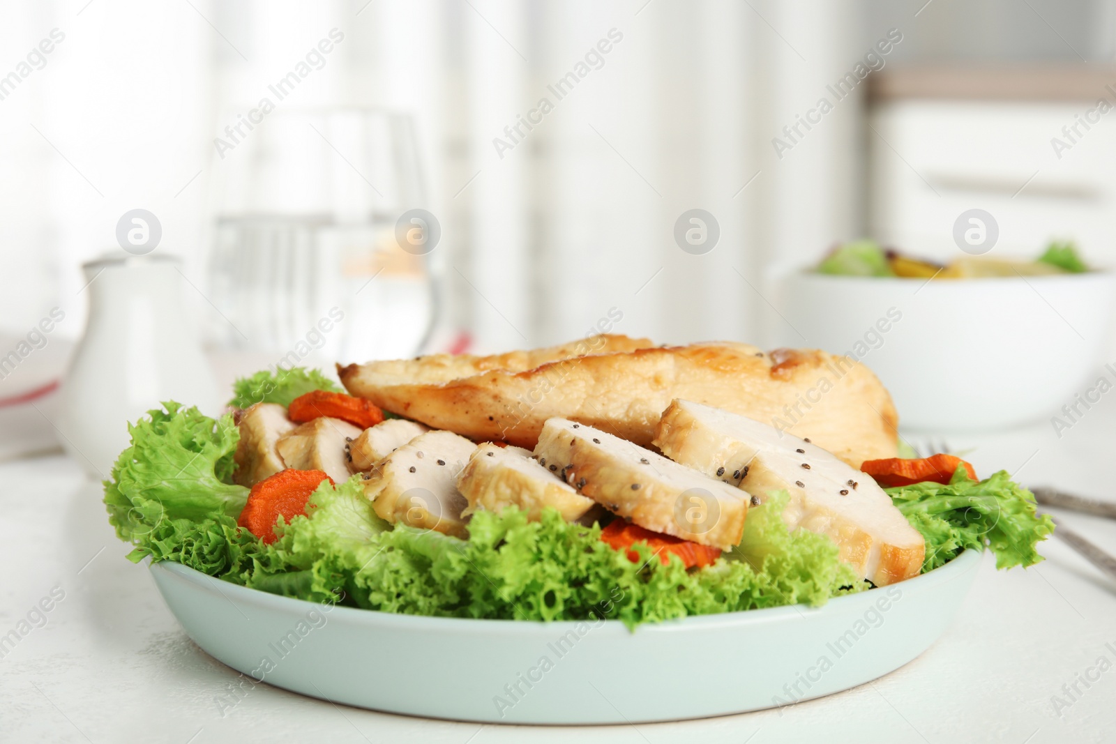 Photo of Tasty cooked chicken fillet with fresh salad served on white table in kitchen. Healthy meals from air fryer