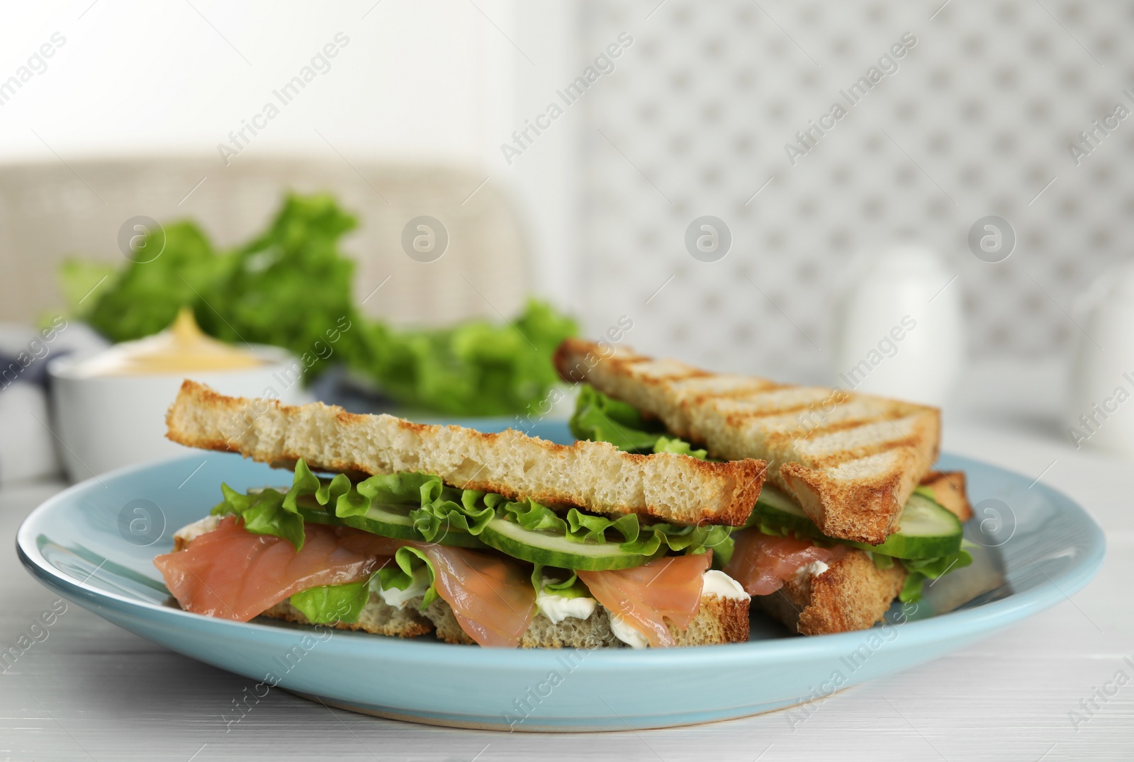 Photo of Blue plate with tasty sandwiches on white table. Space for text
