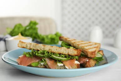 Blue plate with tasty sandwiches on white table. Space for text