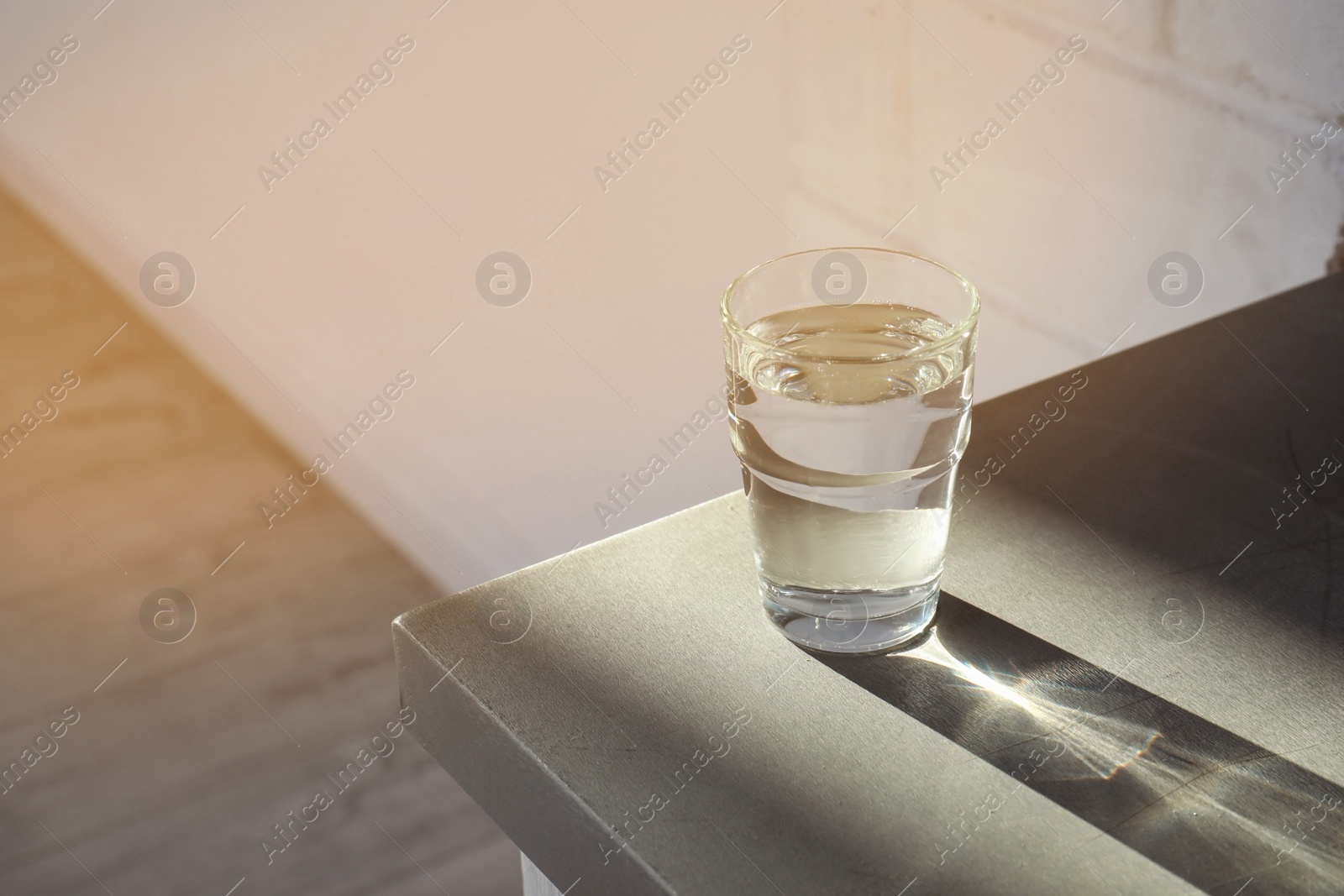 Photo of Glass of pure water on table indoors. Space for text