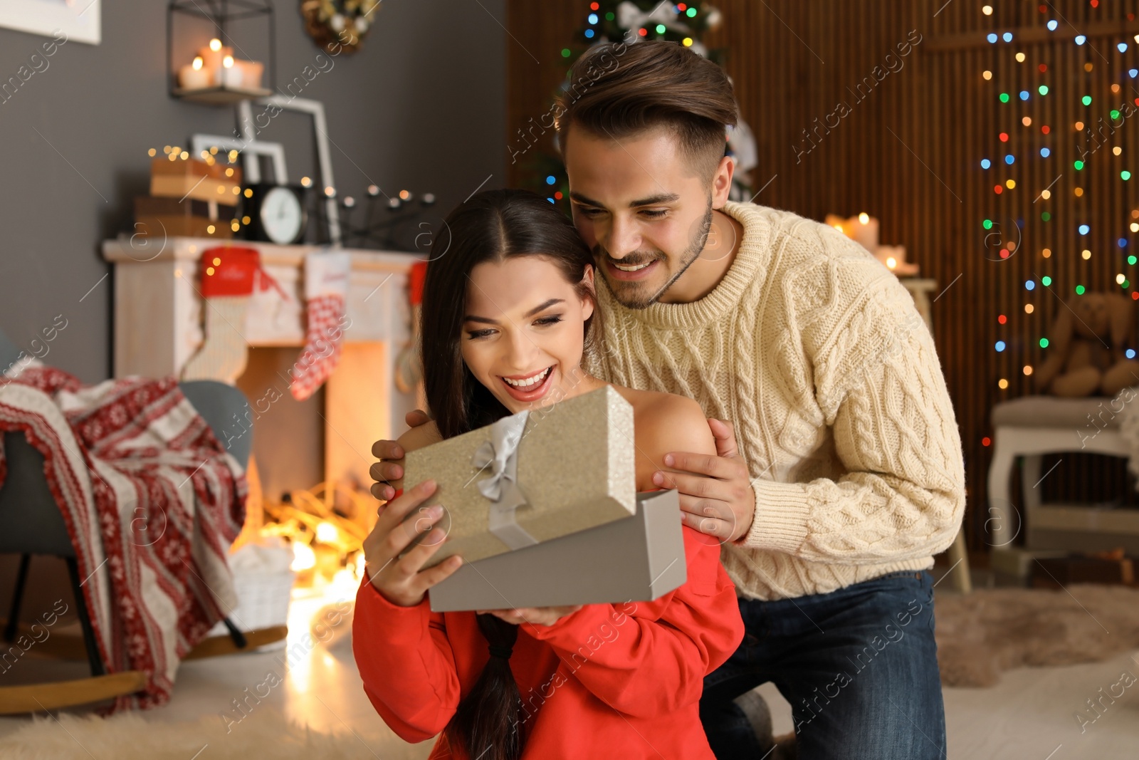 Photo of Young couple with Christmas gift box at home