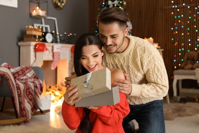 Young couple with Christmas gift box at home