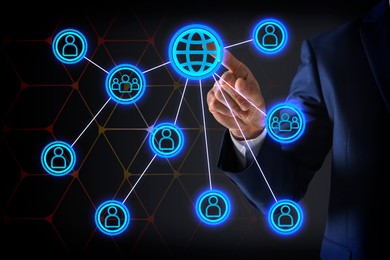 Image of Multi-level marketing. Businessman touching scheme on digital screen against dark background, closeup. Illustration of hierarchy