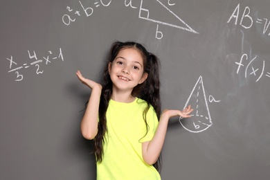 Little school child and mathematical formulas on grey background