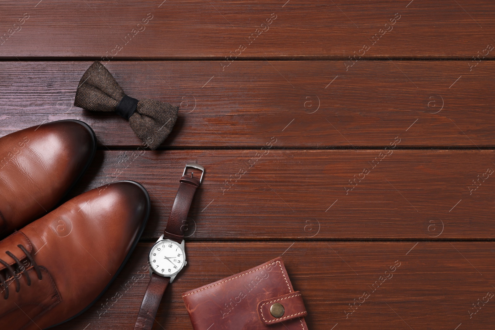Photo of Stylish brown bow tie, shoes, wristwatch and wallet on wooden background, flat lay. Space for text