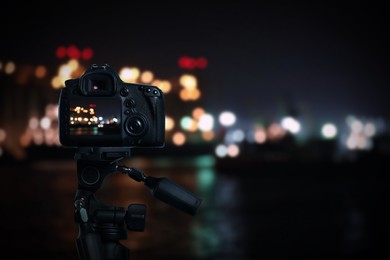 Image of Taking photo of beautiful cityscape at night with camera mounted on tripod