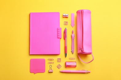Photo of Pink school stationery on yellow background, flat lay