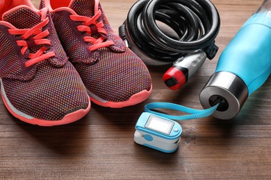 Photo of Different cycling accessories on wooden table, closeup