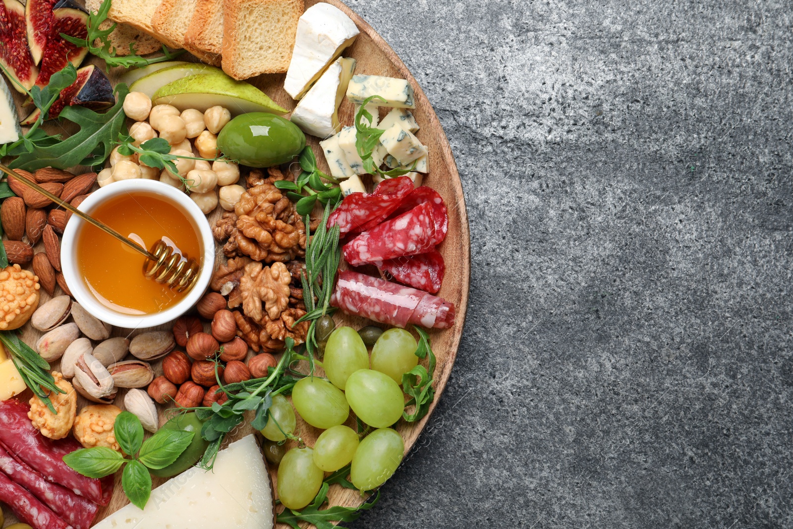 Photo of Different tasty appetizers on dark grey table, top view. Space for text