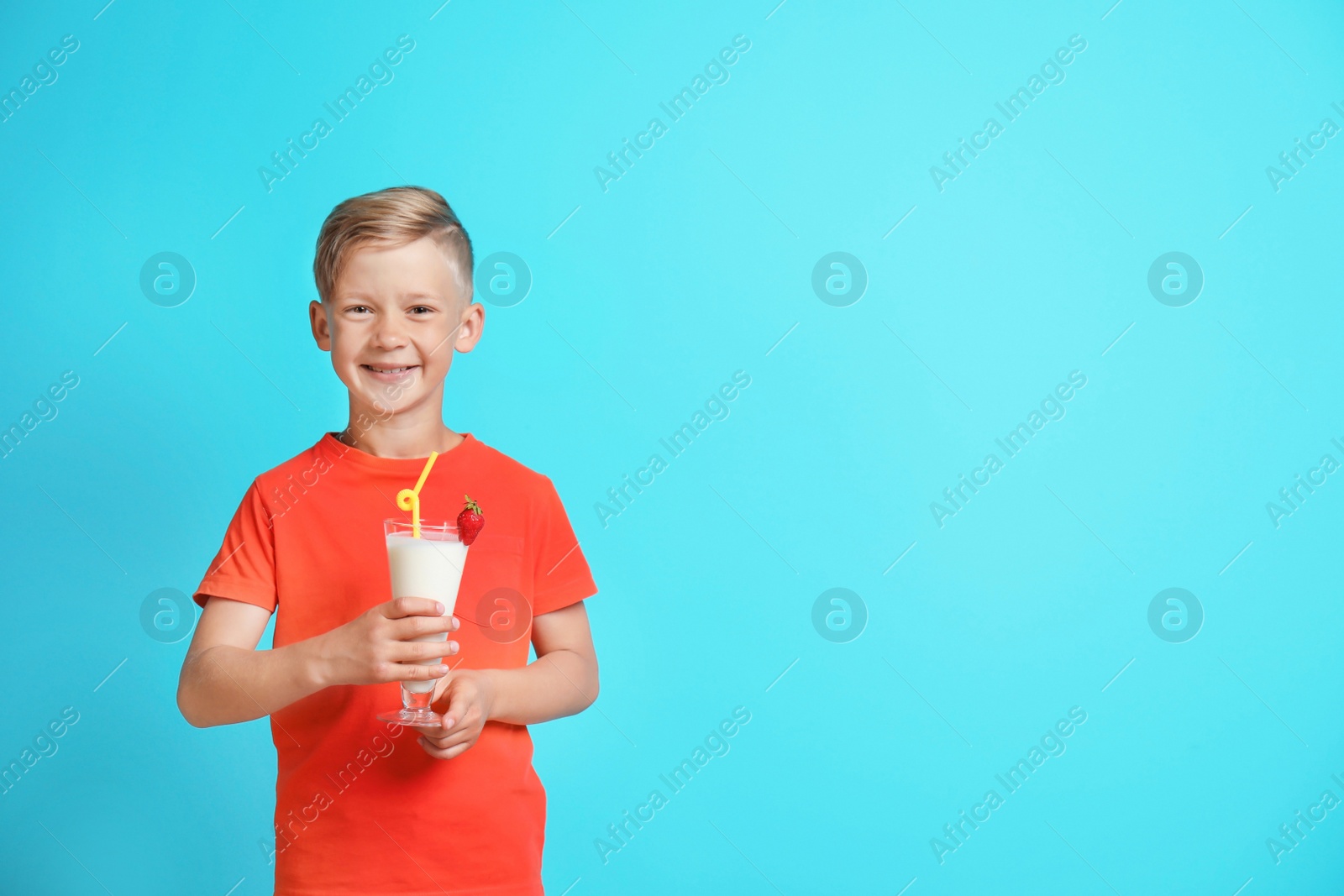 Photo of Little boy with glass of milk shake on color background