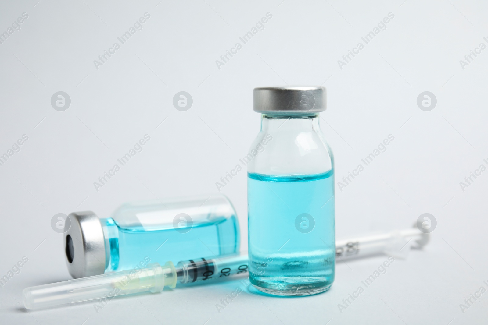 Photo of Vials and syringe on light background. Vaccination and immunization