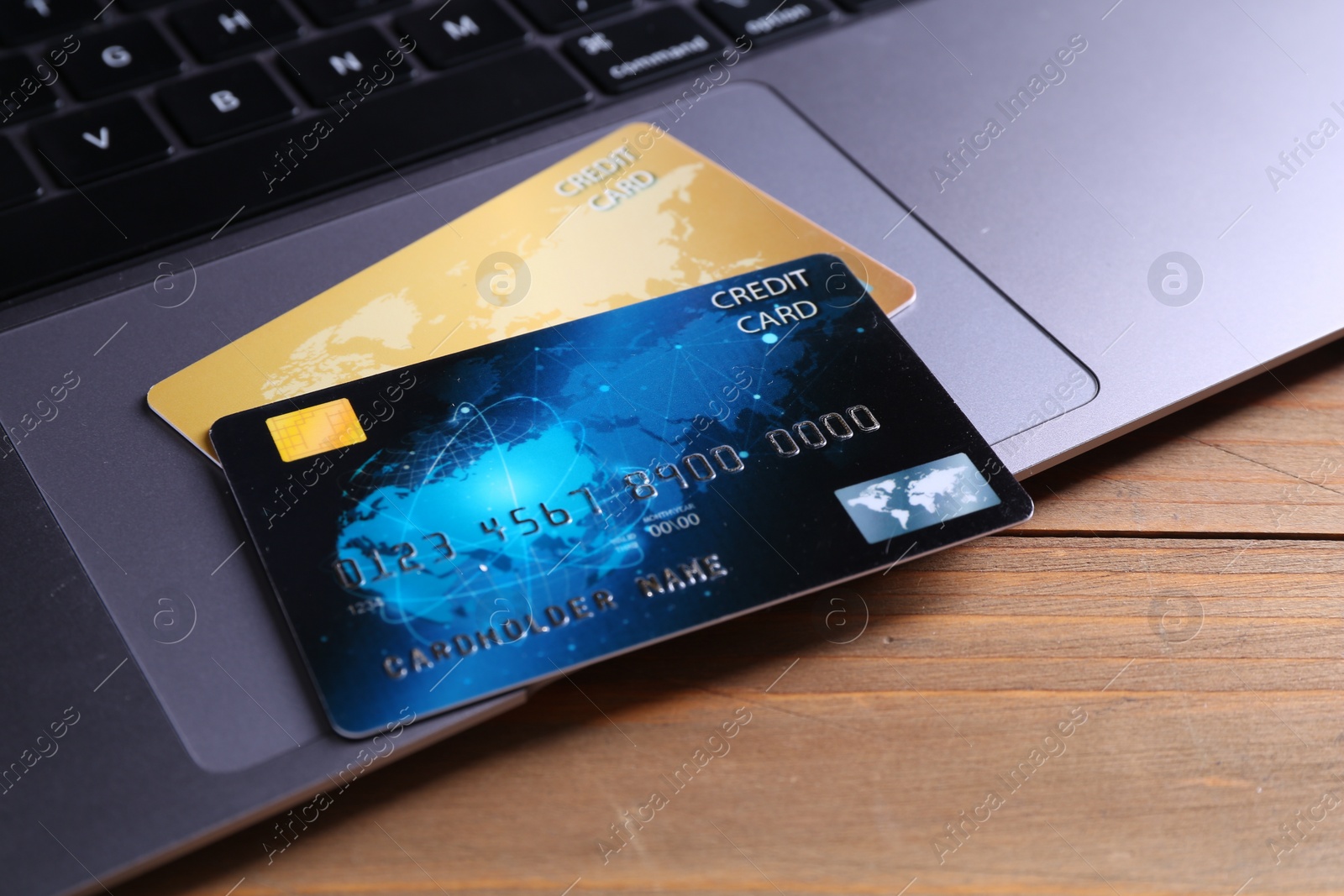 Photo of Credit cards and laptop on wooden table