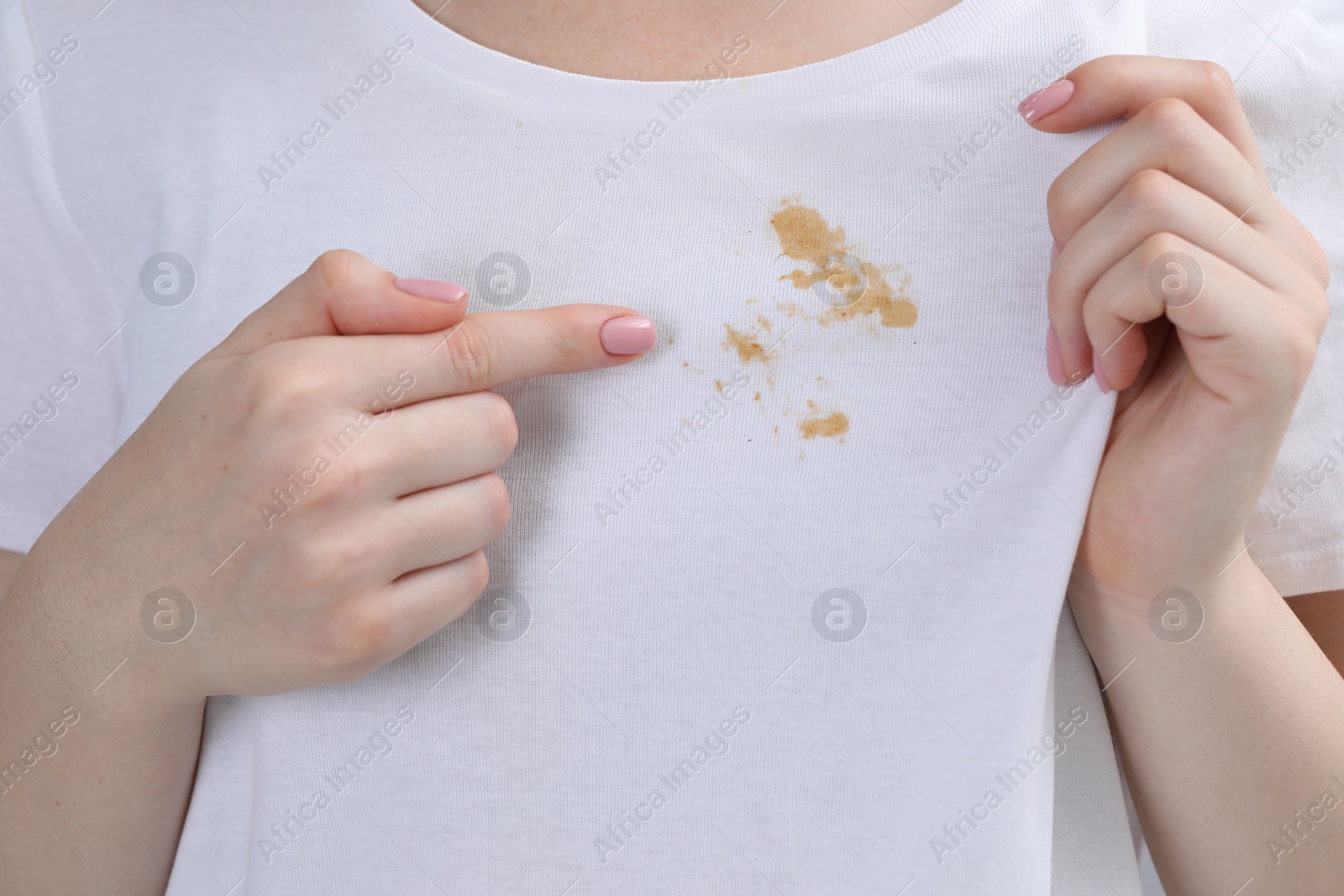 Photo of Woman showing stain on her t-shirt, closeup