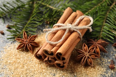 Different spices and fir branches on table, closeup