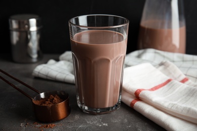 Photo of Glass with tasty chocolate milk on gray table. Dairy drink