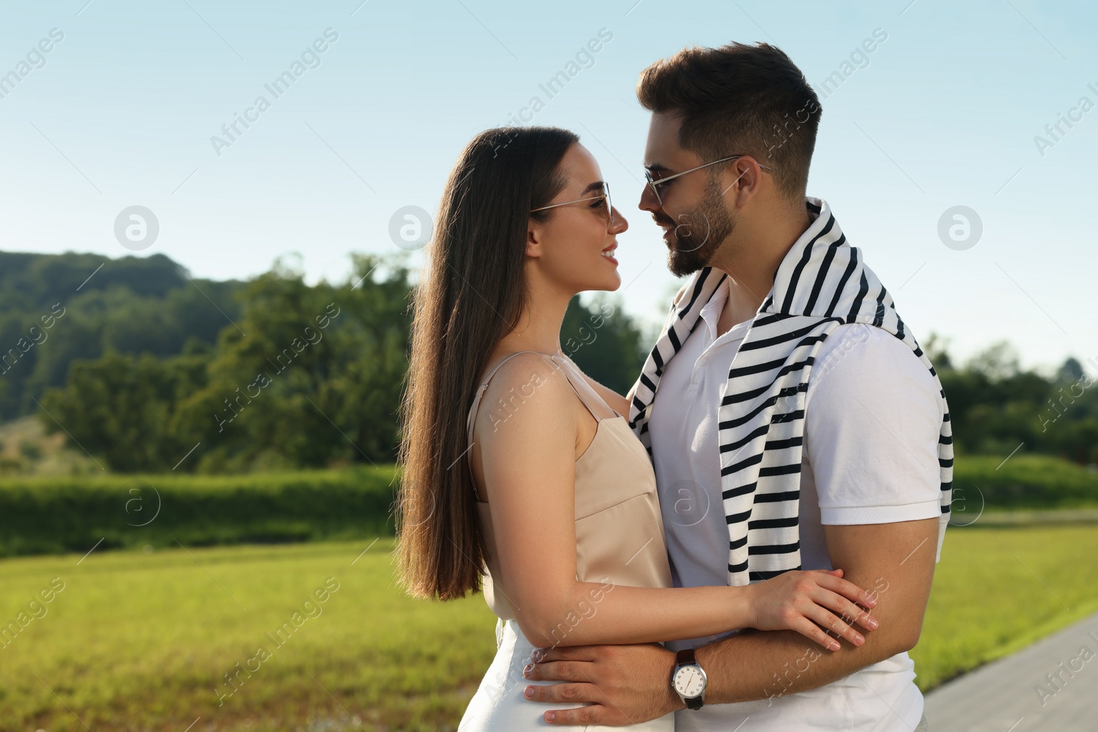 Photo of Romantic date. Beautiful couple spending time together in park, space for text