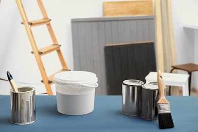 Paint and brush on blue wooden table indoors