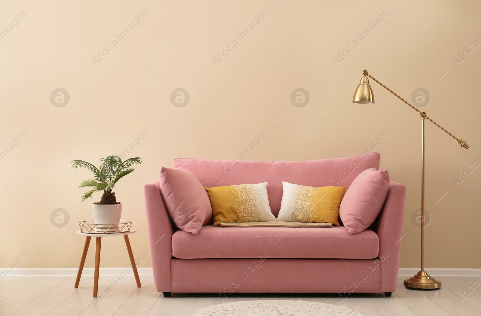 Photo of Simple living room interior with modern sofa near color wall. Space for text