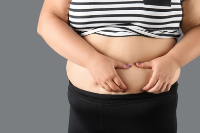 Photo of Overweight woman on gray background, closeup view