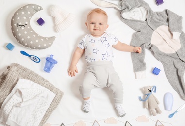 Photo of Cute little baby with clothing and accessories on white background, top view