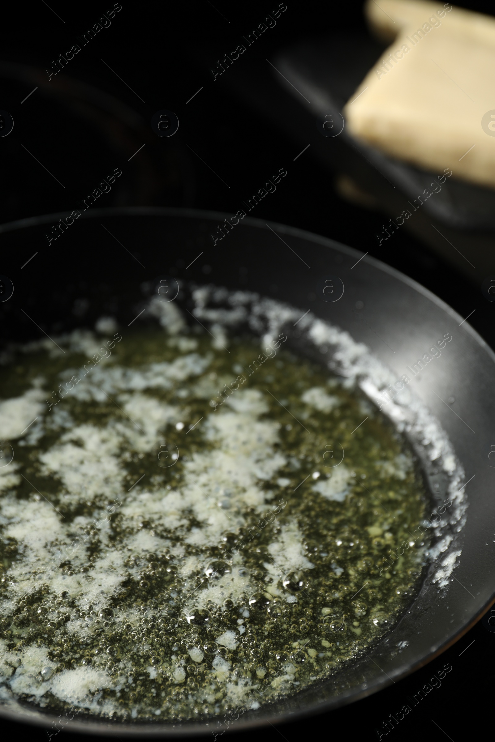 Photo of Melting butter in frying pan on table, closeup