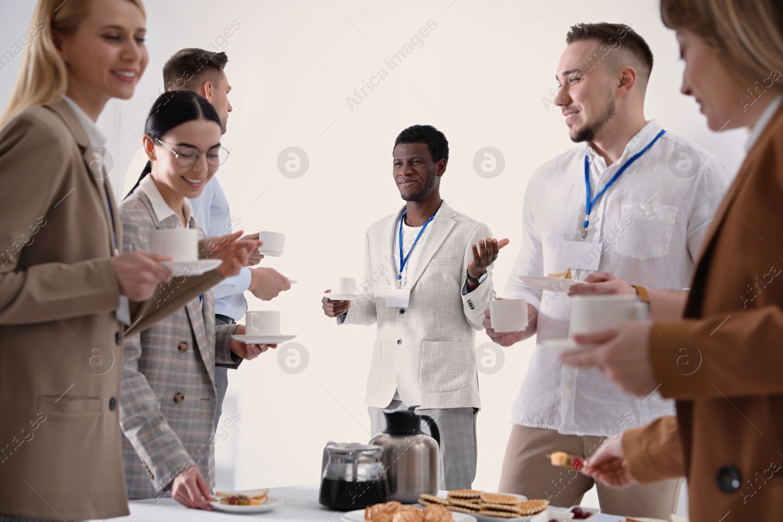 Photo of Group of people chatting during coffee break indoors