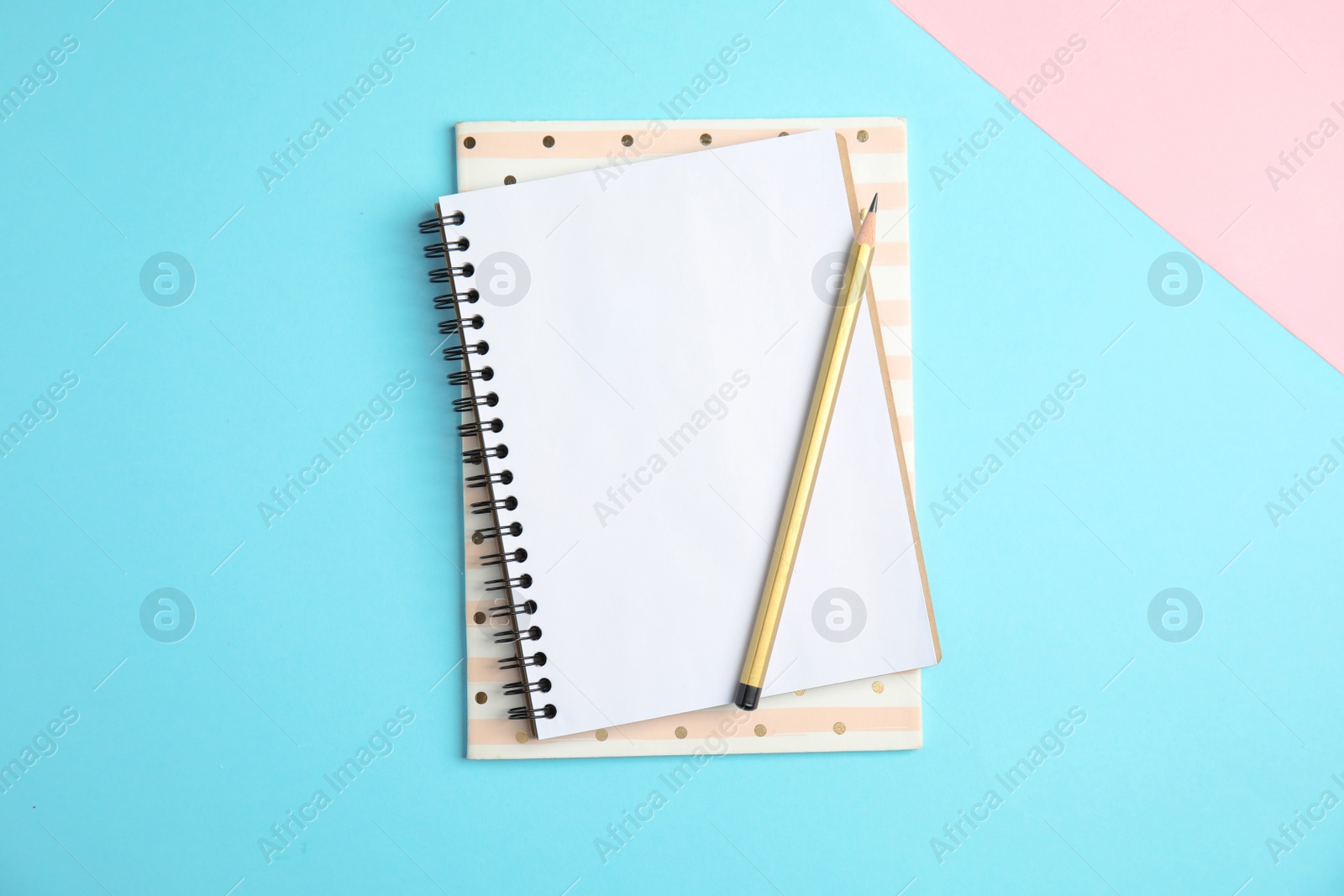 Photo of Notebooks and pencil on color background, top view