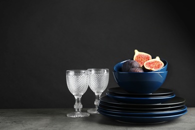 Photo of Composition with dinnerware on table against dark background, space for text. Interior element