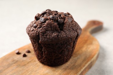 Photo of Delicious chocolate muffin on light table, closeup