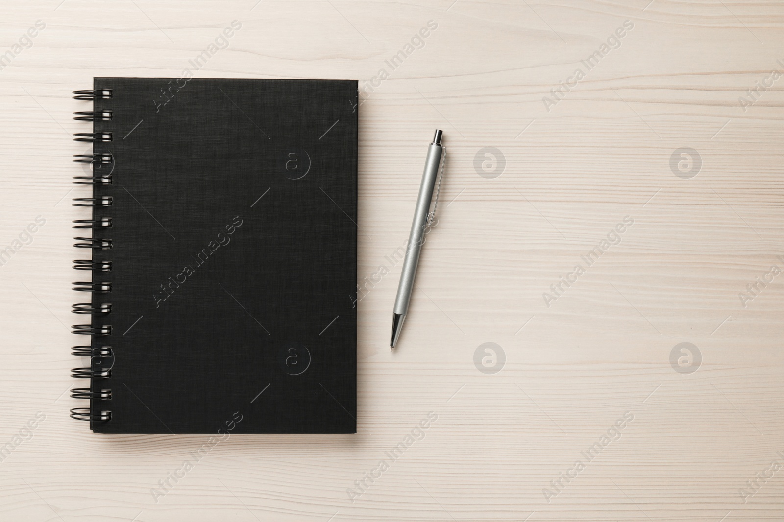 Photo of Notebook and pen on white wooden table, flat lay . Space for text