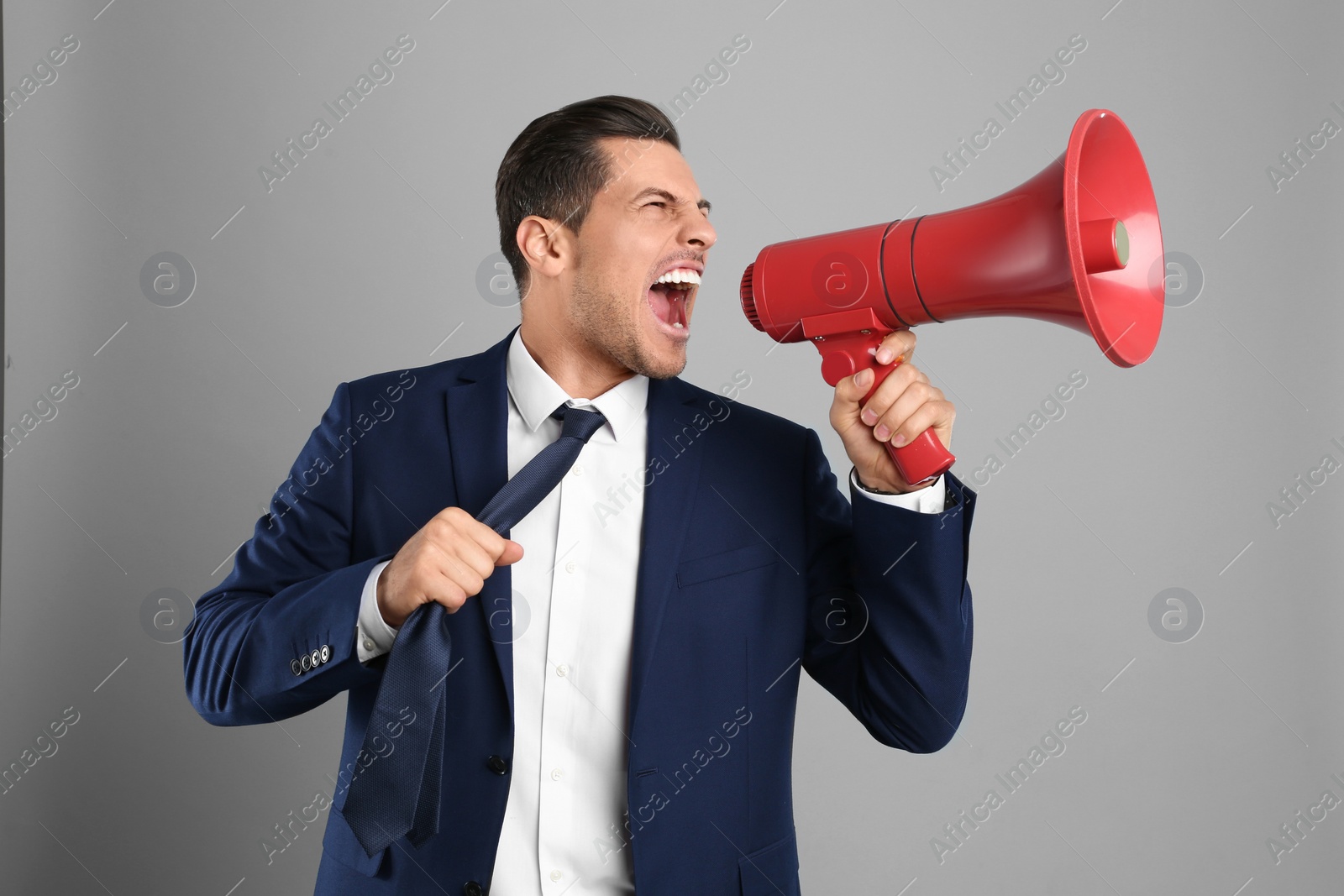 Photo of Handsome man with megaphone on grey background