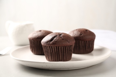 Photo of Delicious chocolate cupcakes on white table, closeup